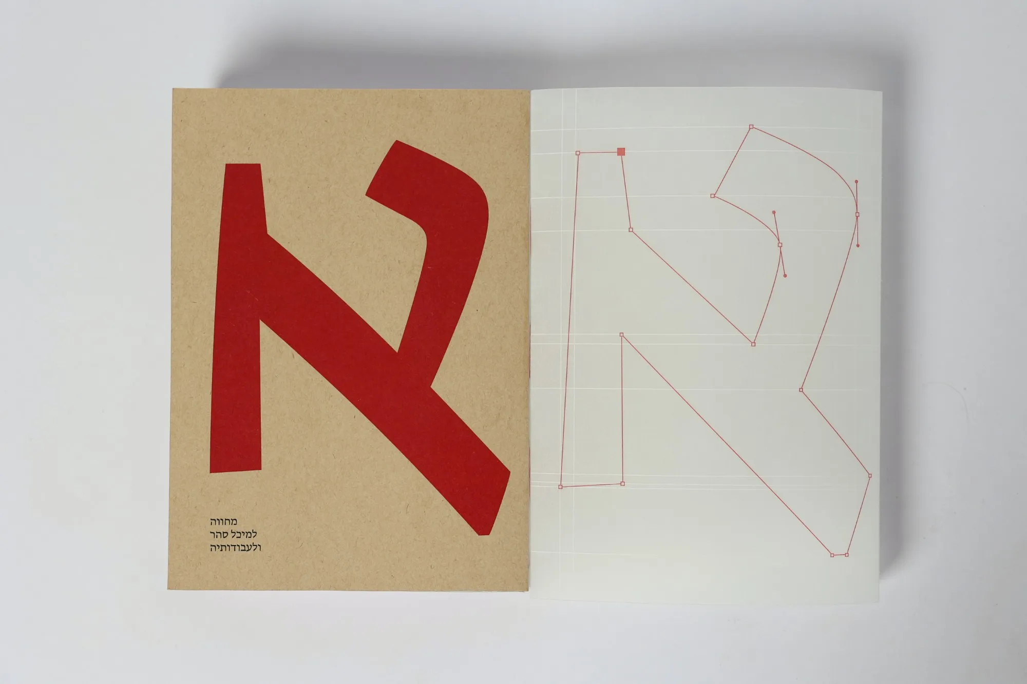 The catalogue's kraft cover and its translucent jacket laid flat side by side on a grey table