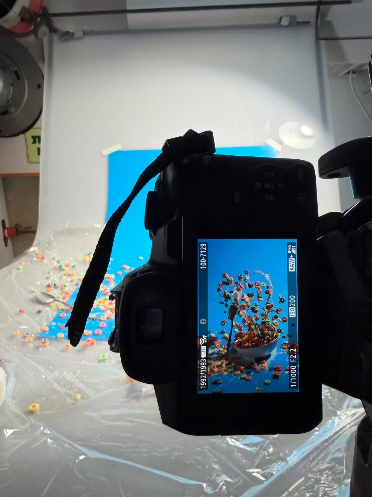 A camera screen showing a photograph of cereal splashing out of a bowl against a blue background